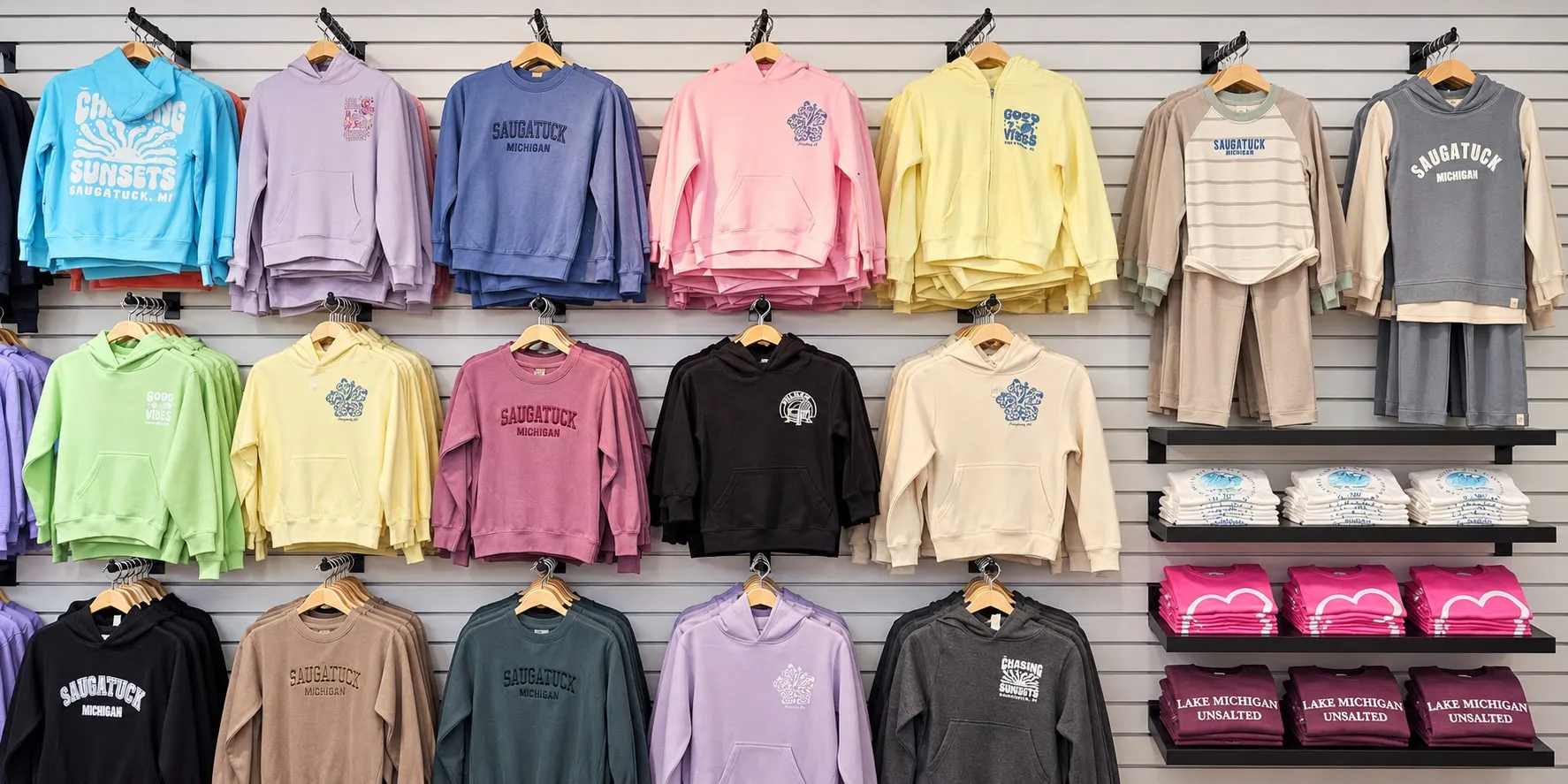 A wall of youth hoodies, crewnecks and zip-ups in blue, lavender, pink, yellow, green, black and cream